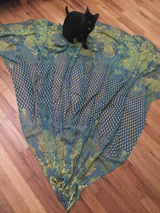 2) I cut all the scarves (12 total, I think) diagonally, corner-to-corner, to make long triangles that I sewed back together into two big triangle-like shapes – a larger panel for the back of the skirt and a narrower one for the front, creating a two-panel skirt. Gwen supervises.